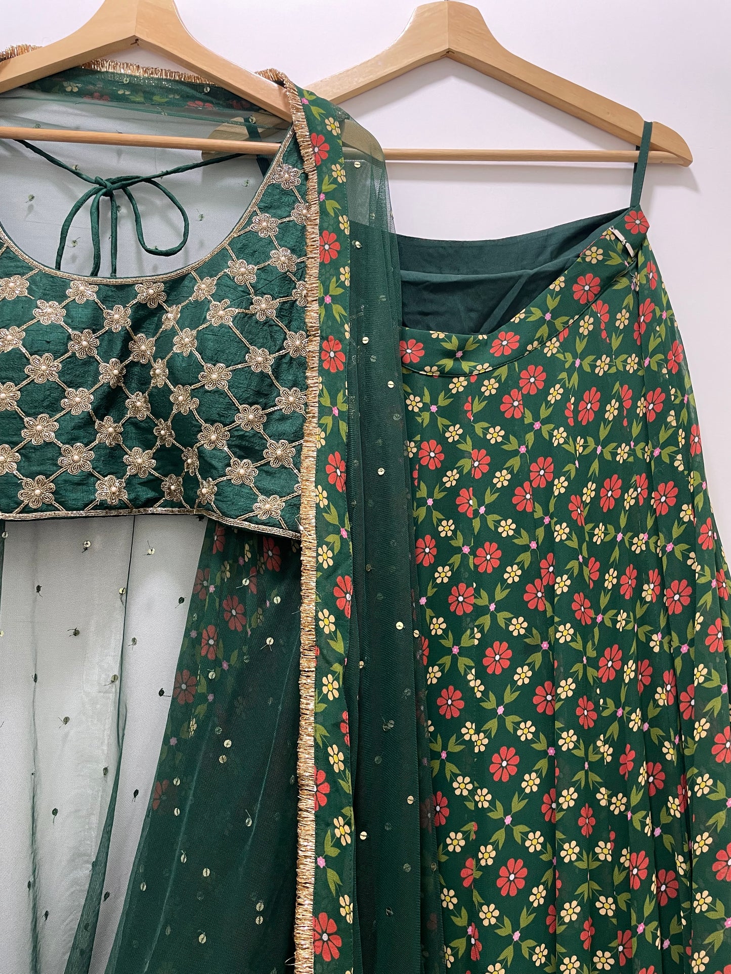 Bottle green hand embroidered criss cross blouse and dupatta with a high waisted floral printed lehenga