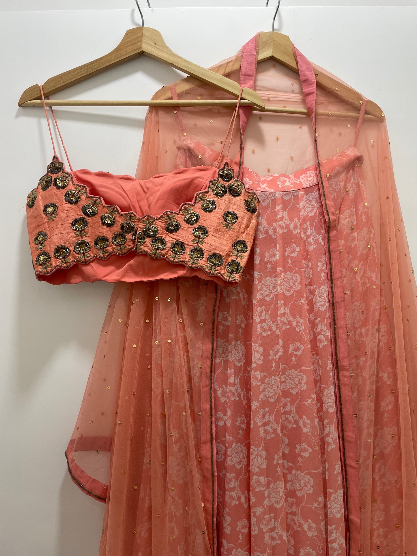 Baby pink hand embroidered strappy blouse and dupatta with a high waisted floral printed lehenga