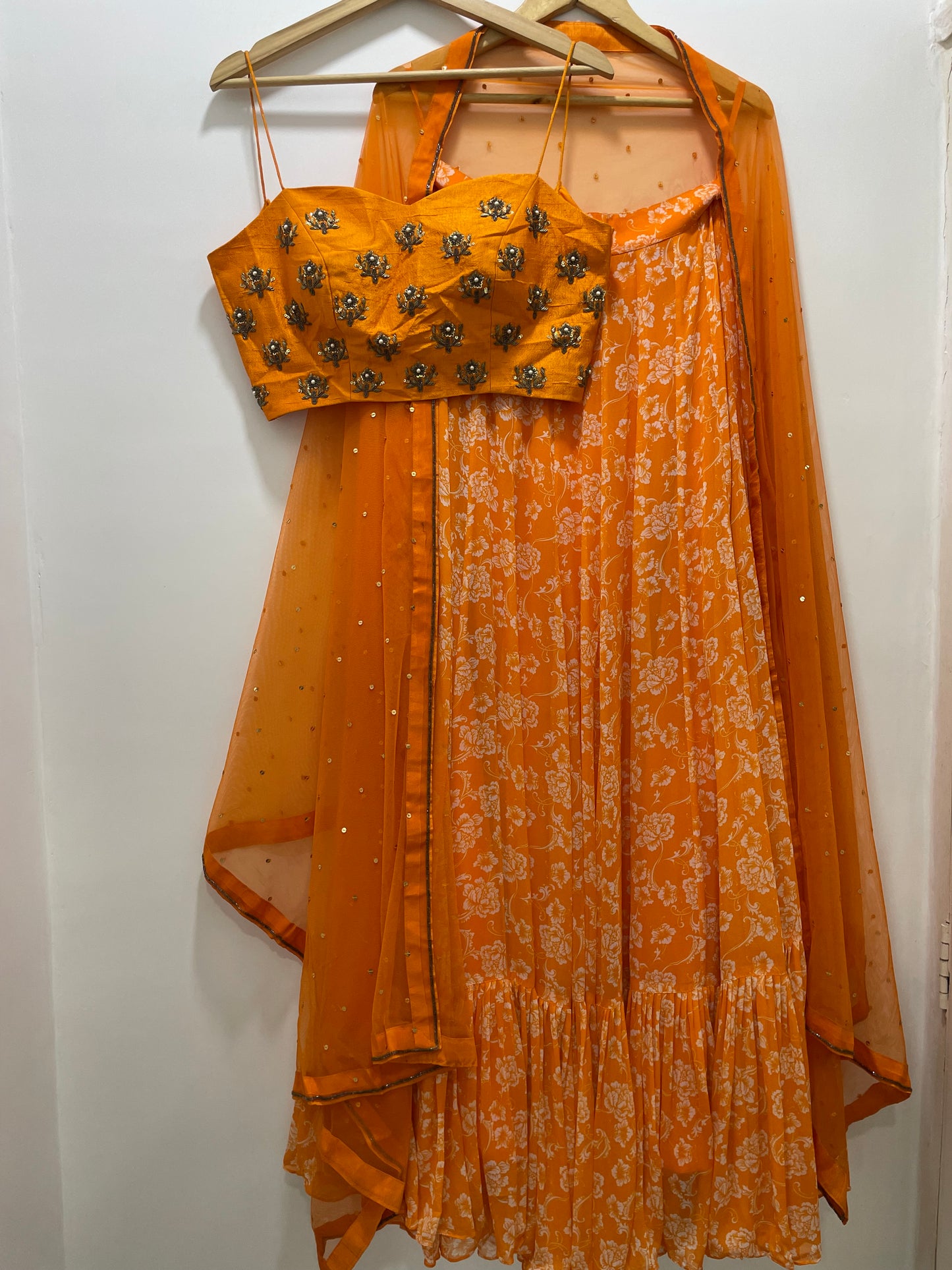 Hand embroidered orange blouse and dupatta with a high waisted floral printed lehenga