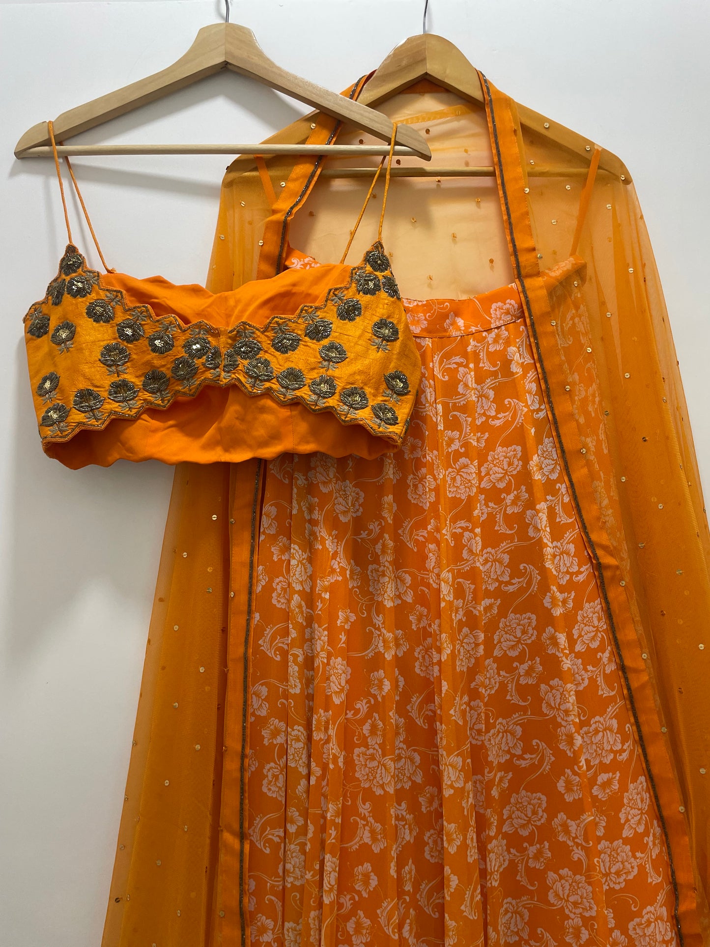 Hand embroidered orange blouse and dupatta with a high waisted floral printed lehenga