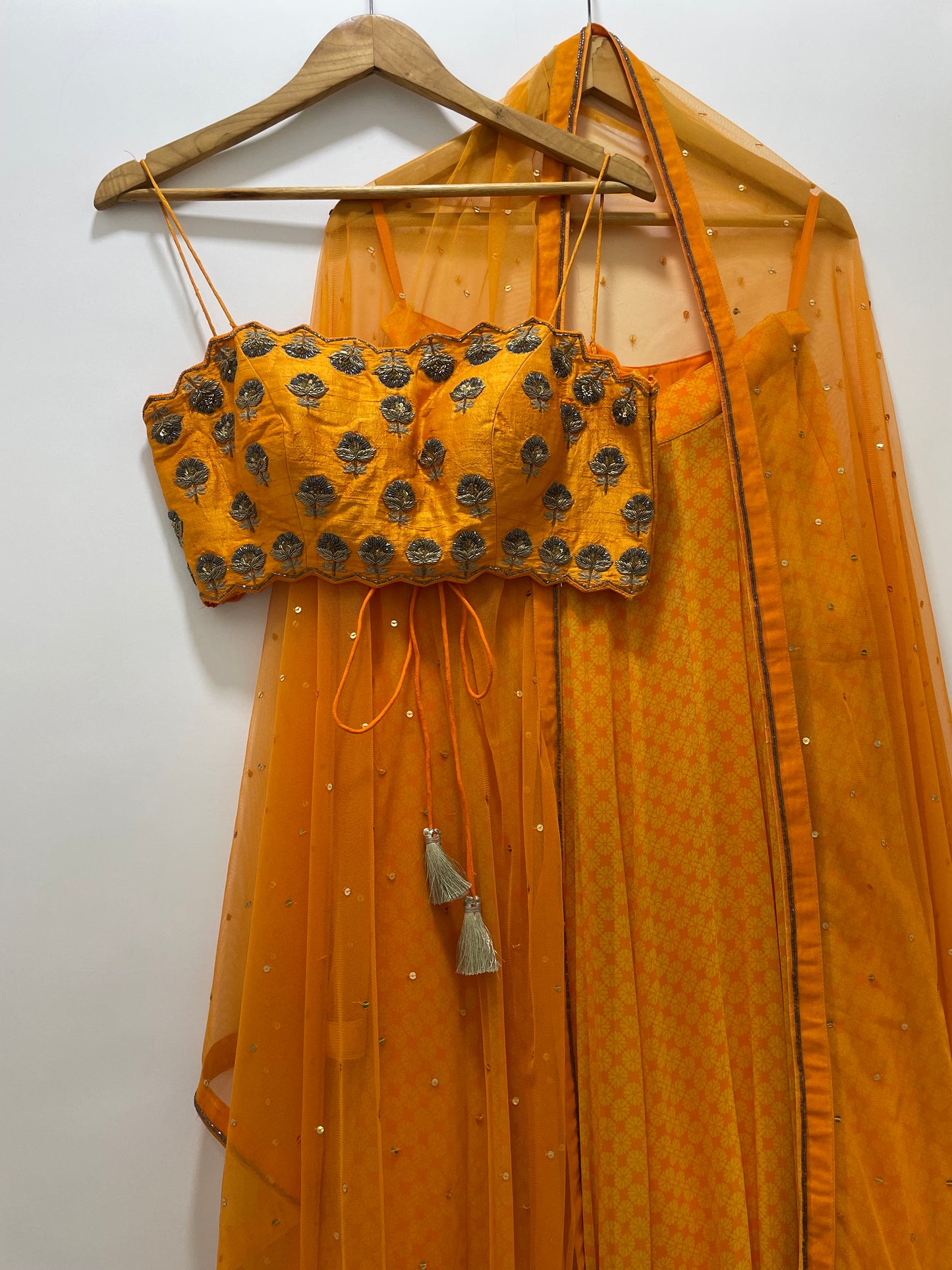 Hand embroidered orange blouse and dupatta with a high waisted geometric floral lehenga
