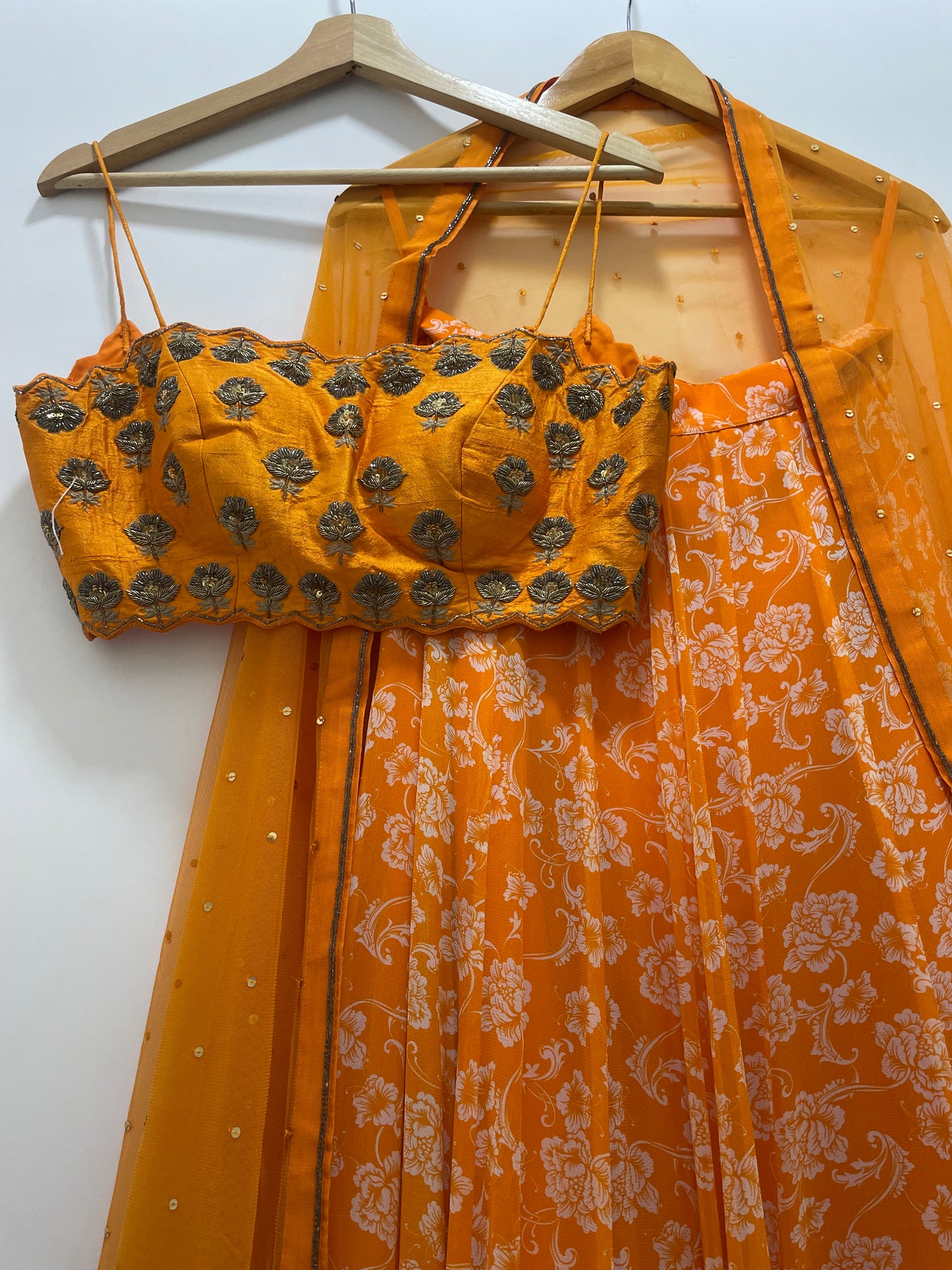 Hand embroidered orange blouse and dupatta with a high waisted floral printed lehenga