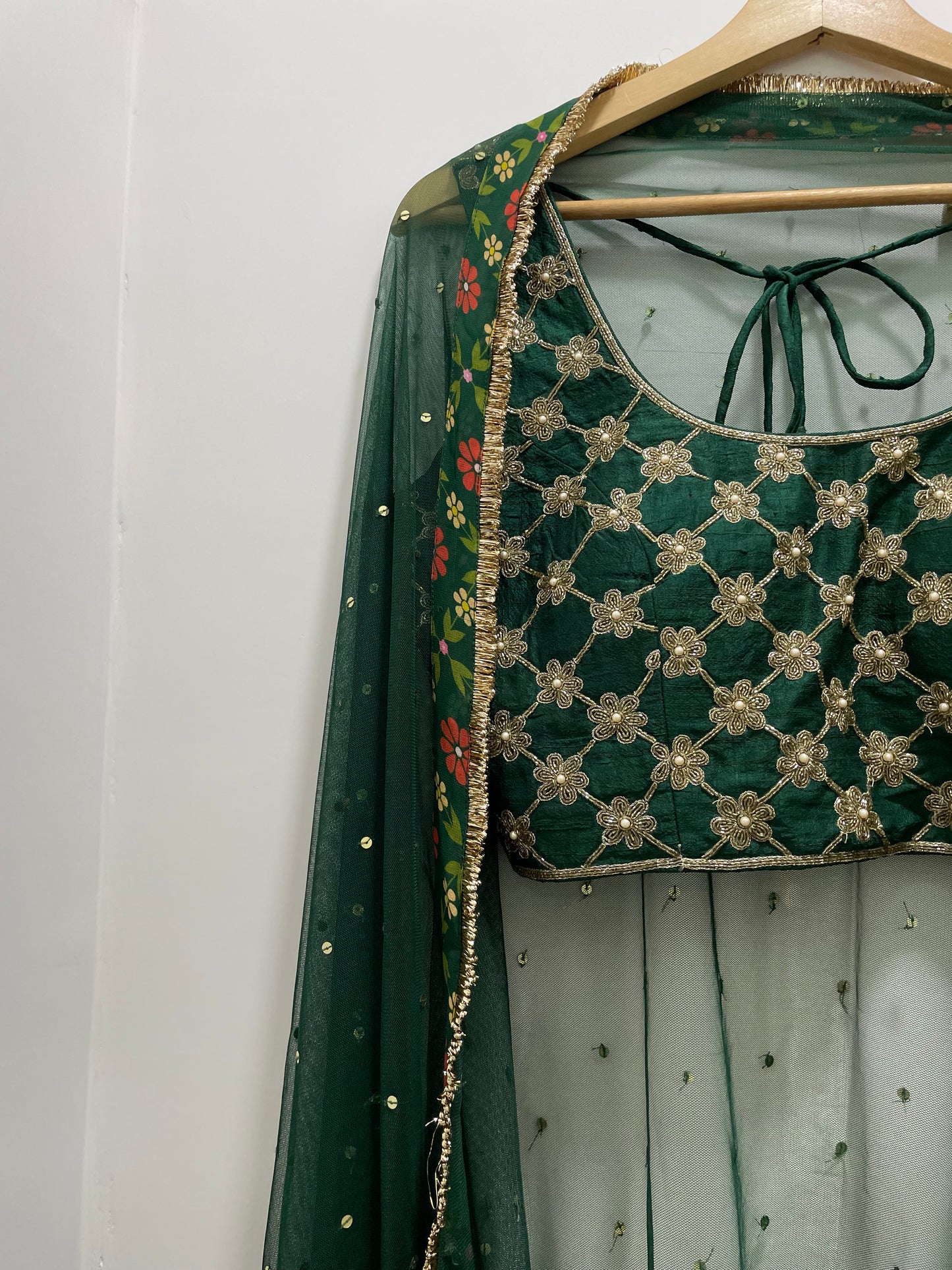 Bottle green hand embroidered criss cross blouse and dupatta with a high waisted floral printed lehenga