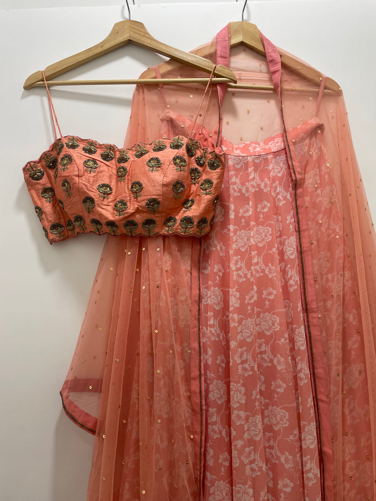 Baby pink hand embroidered strappy blouse and dupatta with a high waisted floral printed lehenga