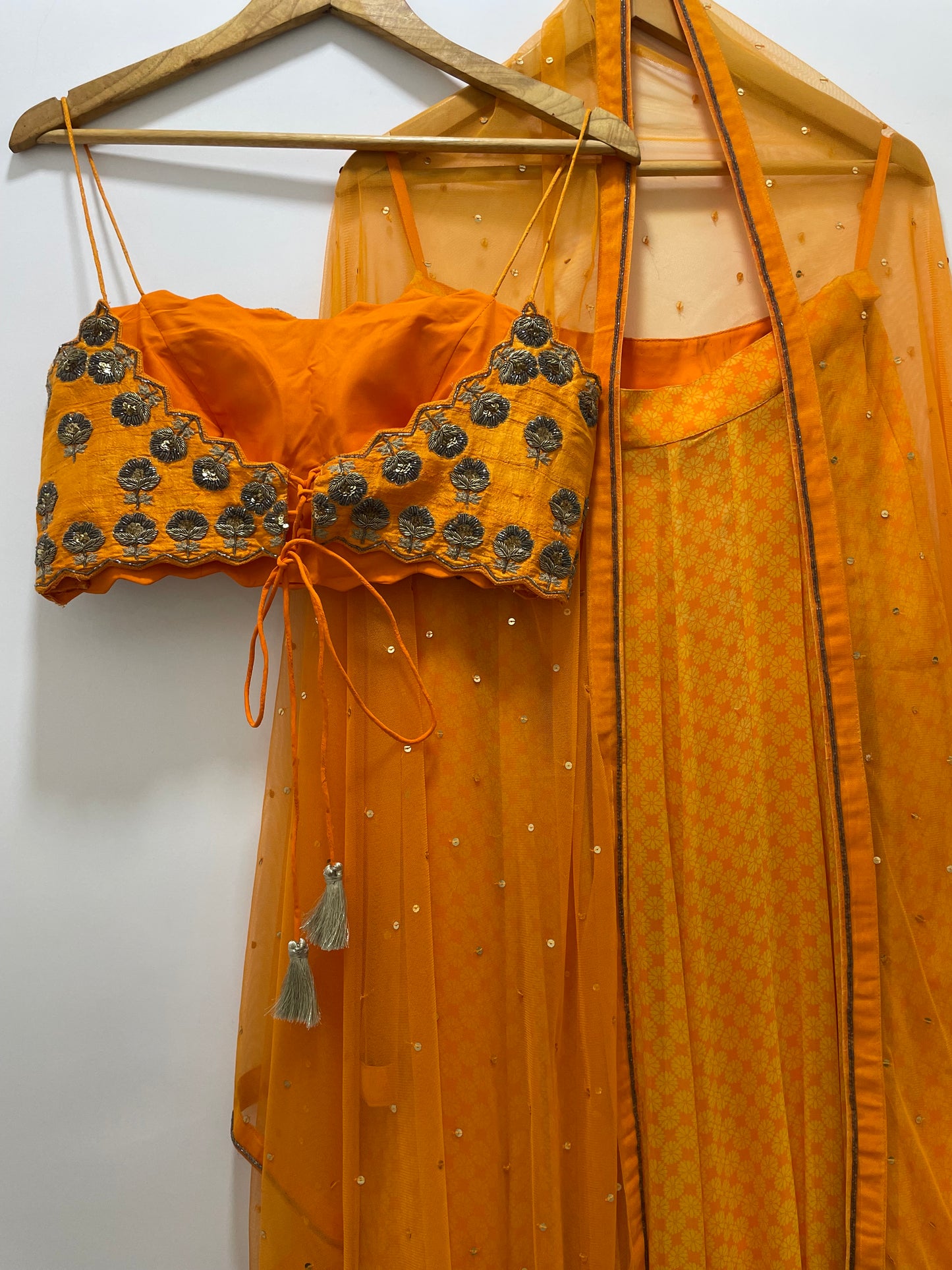 Hand embroidered orange blouse and dupatta with a high waisted geometric floral lehenga