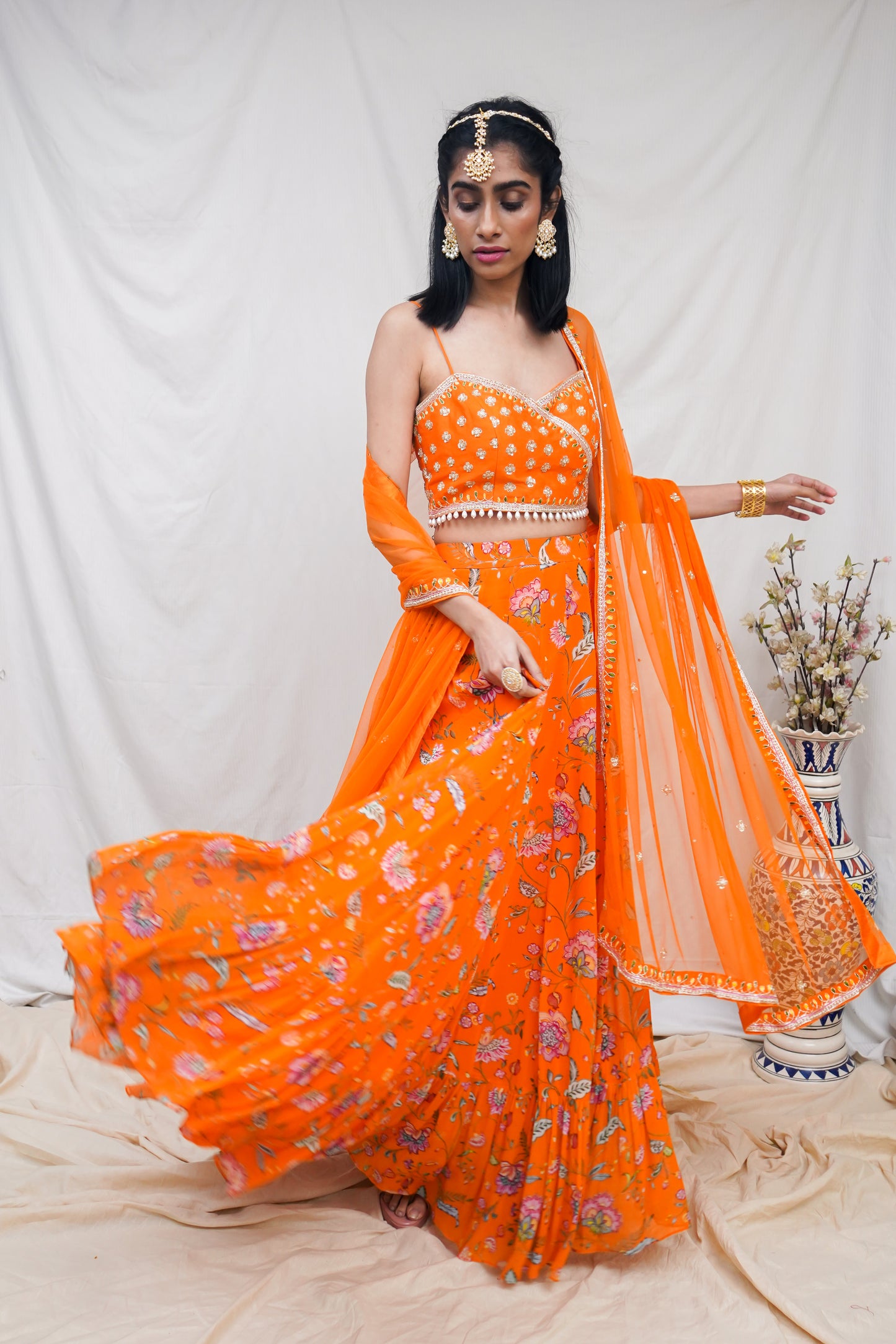 Hand embroidered orange wrap blouse and dupatta with a high waisted floral printed lehenga