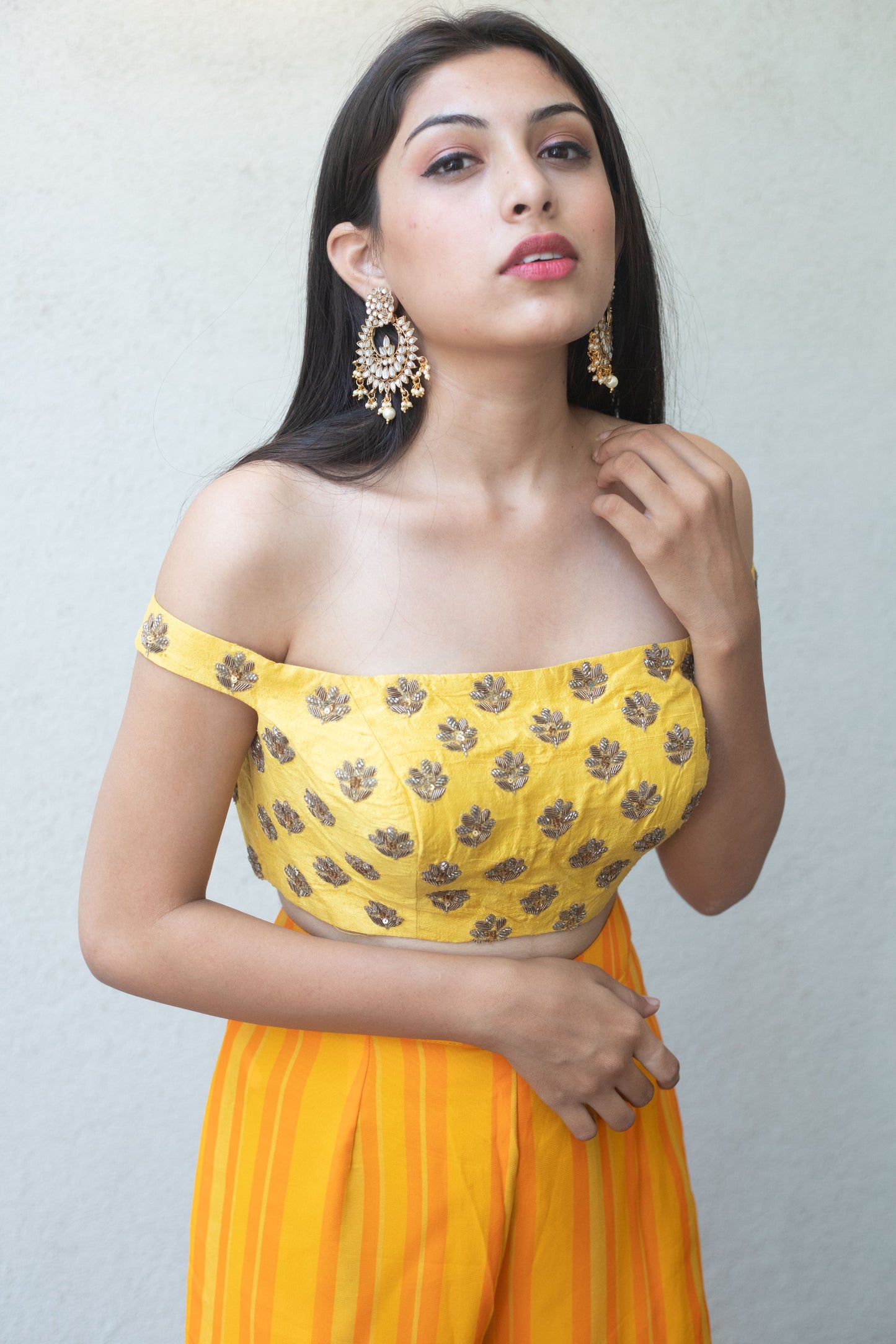 Hand embroidered off shoulder crop with a high waisted yellow striped pant