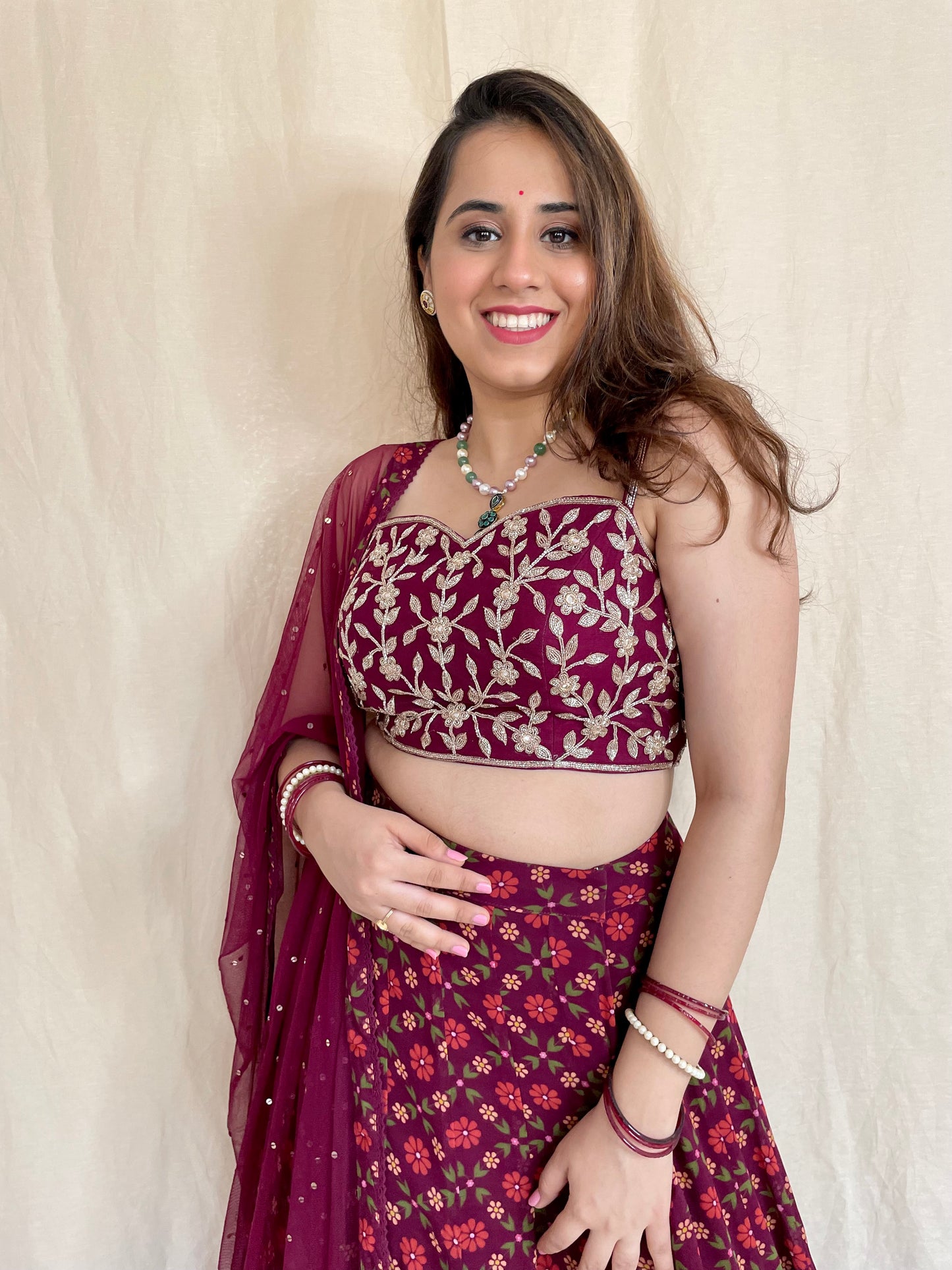 Wine floral printed lehenga with a hand embroidered strappy gold blouse and dupatta