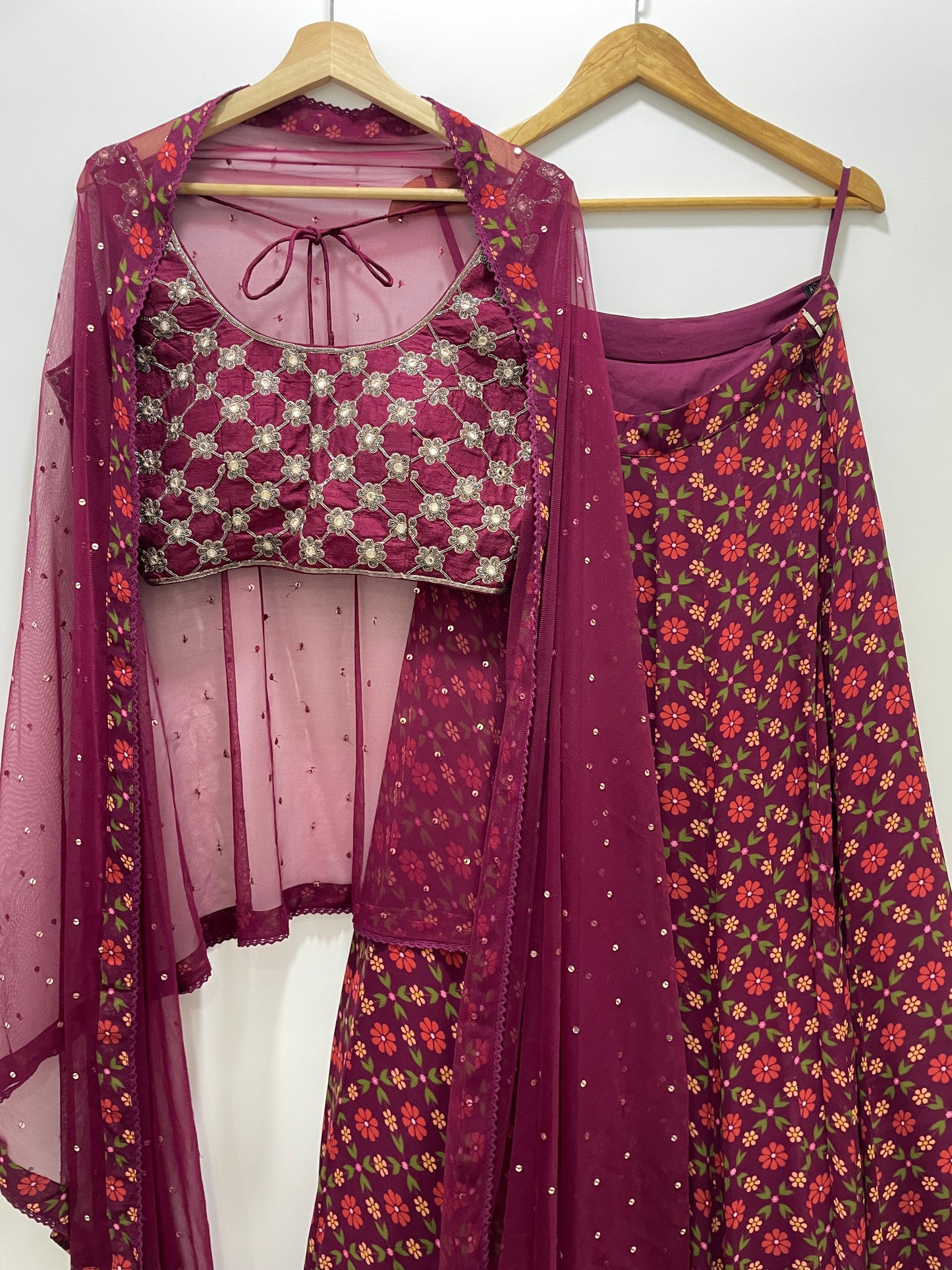 Hand embroidered wine criss cross blouse and dupatta with a high waisted floral printed lehenga