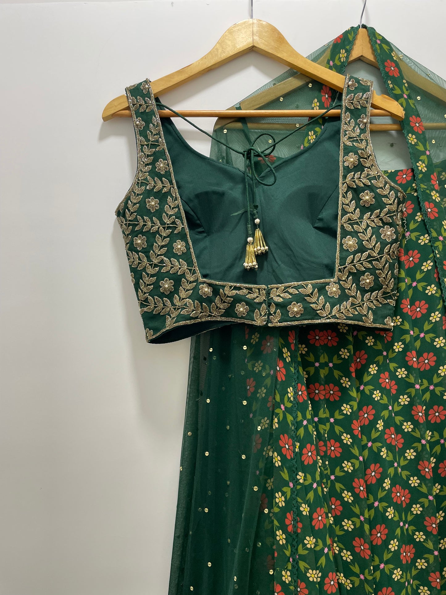 Bottle green hand embroidered gold blouse and dupatta with a high waisted floral printed lehenga