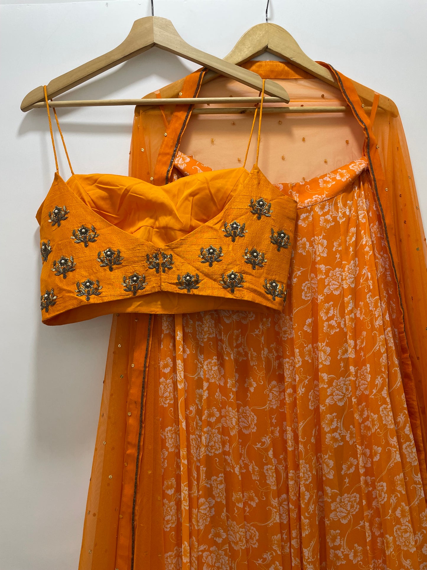 Hand embroidered orange blouse and dupatta with a high waisted floral printed lehenga