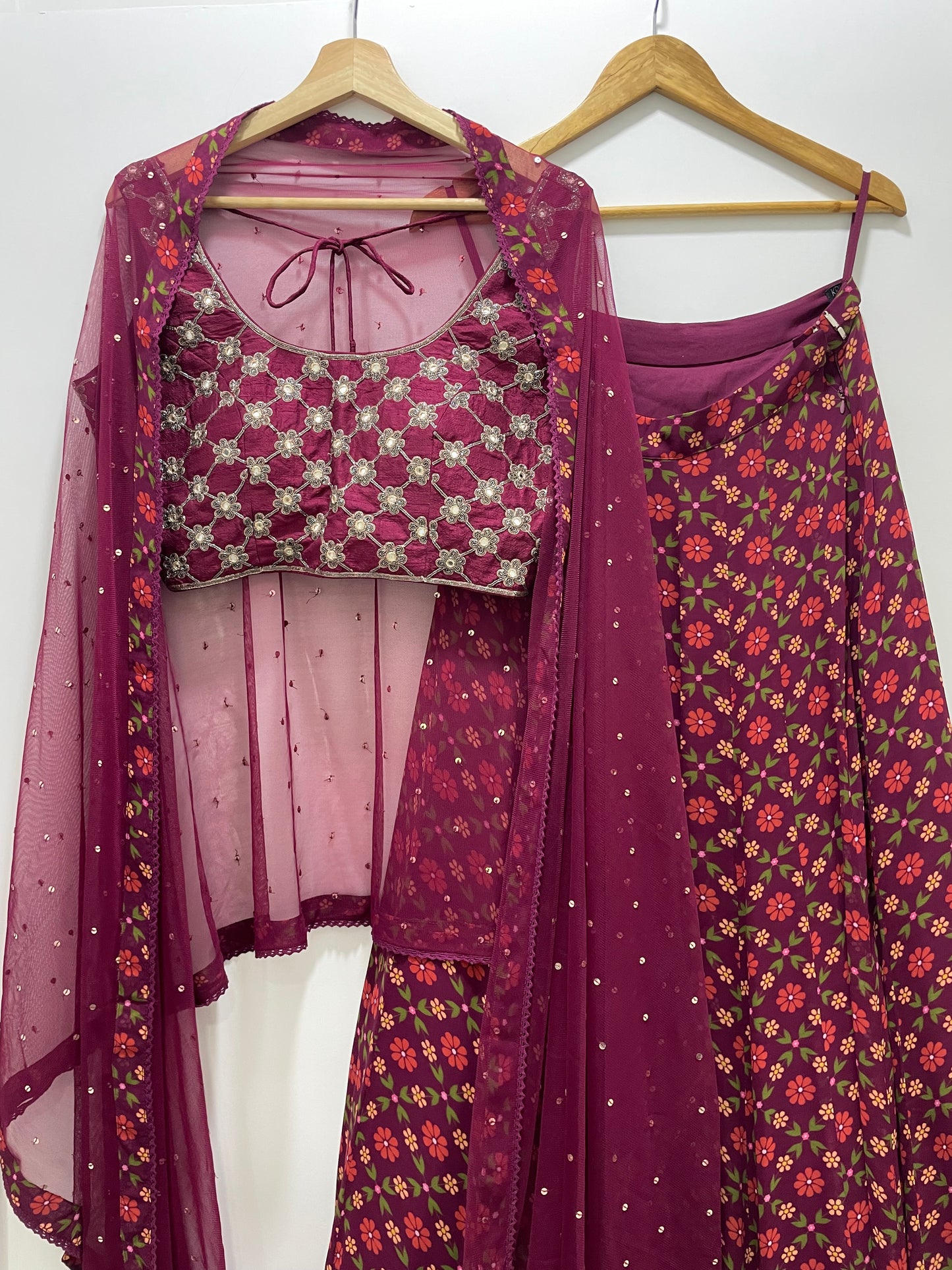Hand embroidered wine criss cross blouse and dupatta with a high waisted floral printed lehenga