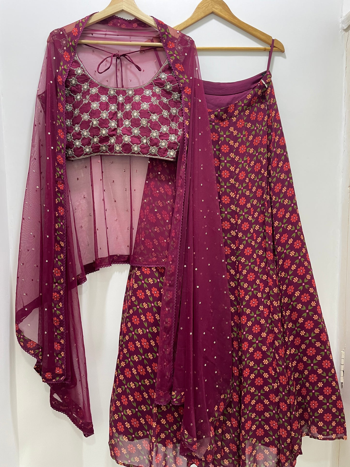 Hand embroidered wine criss cross blouse and dupatta with a high waisted floral printed lehenga