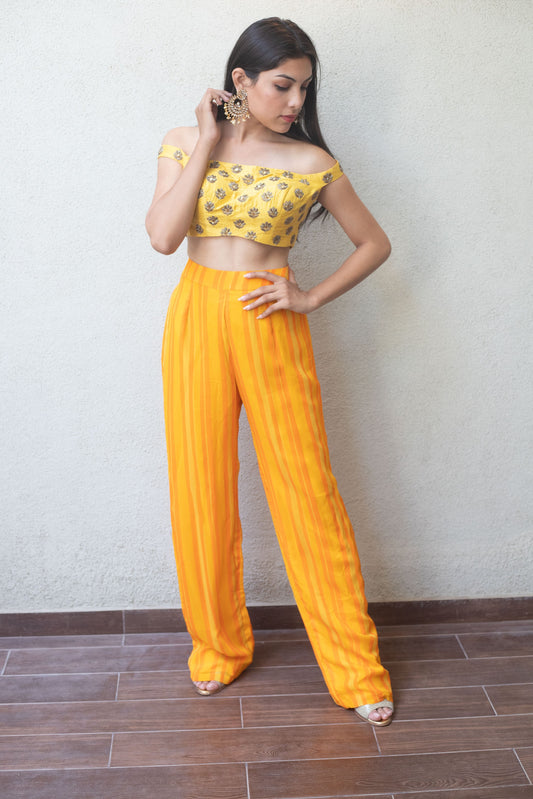 Hand embroidered off shoulder crop with a high waisted yellow striped pant