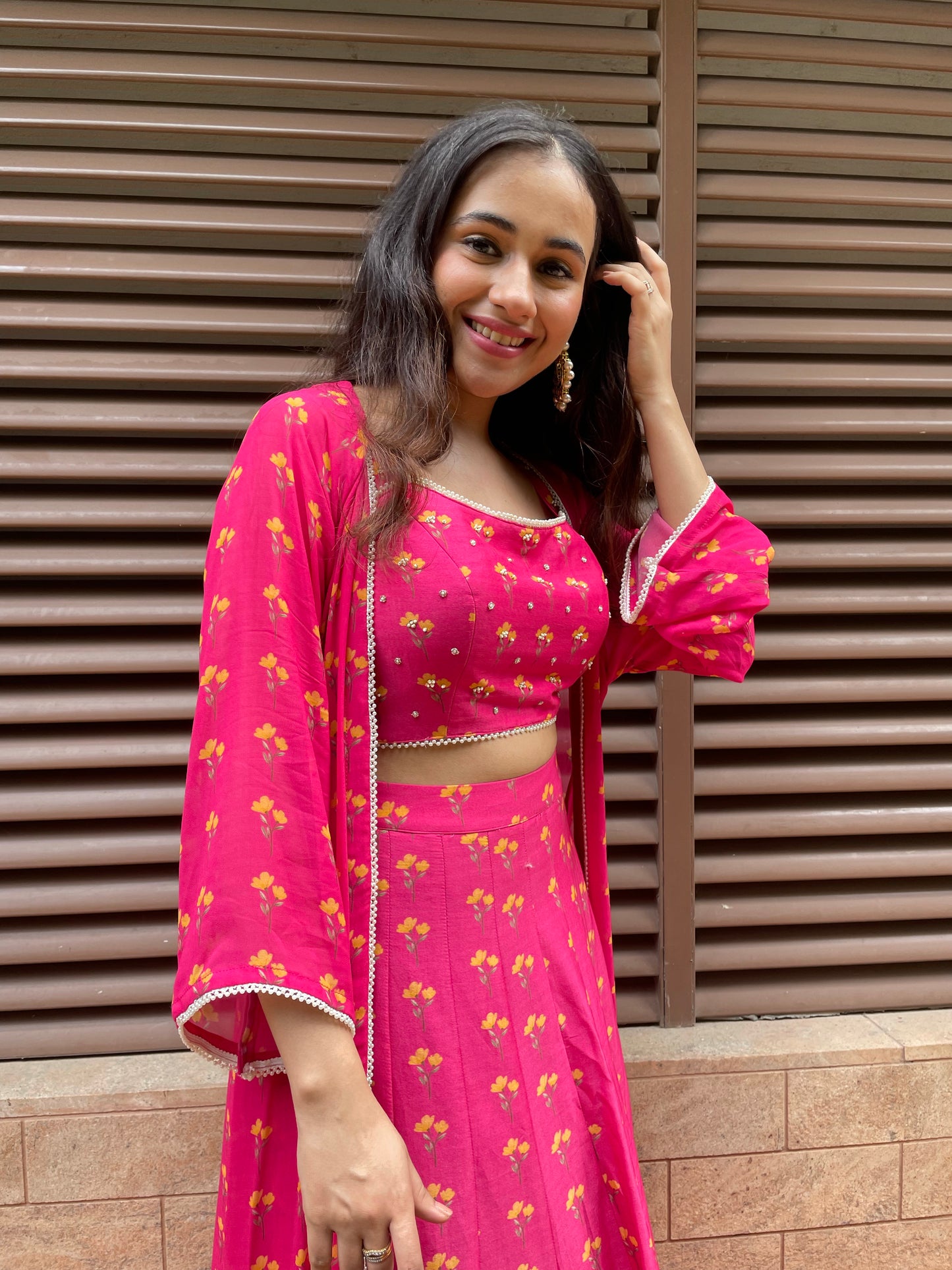 Rani pink floral printed lehenga with a printed blouse highlighted with intricate hand embroidery and cape
