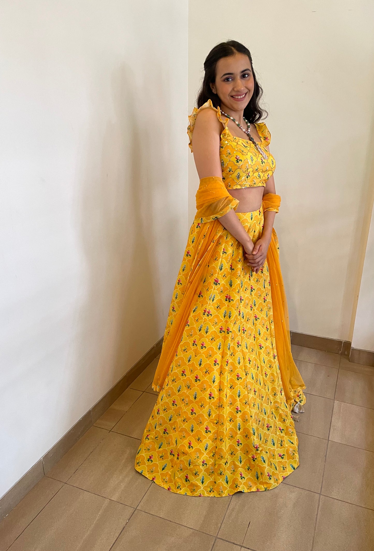 Yellow orange floral print on print lehenga highlighted with intricate hand embroidery