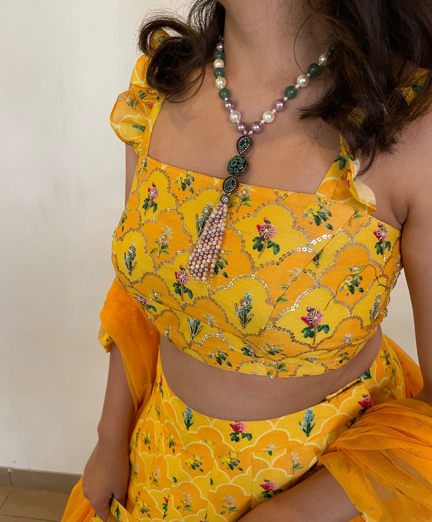 Yellow orange floral print on print lehenga highlighted with intricate hand embroidery